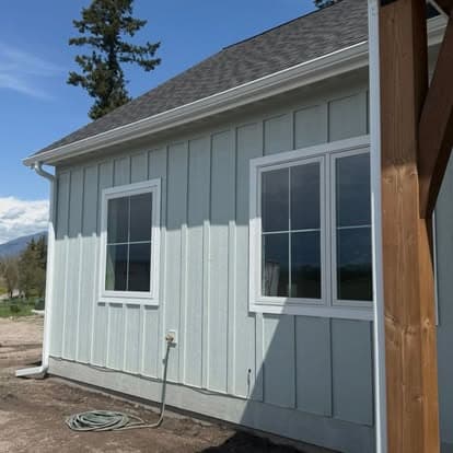 Light blue house exterior featuring two windows and a clear sky backdrop.