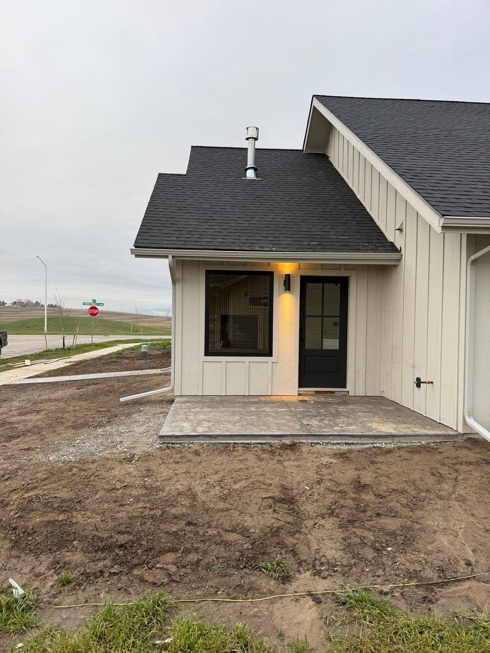 Newly constructed home exterior with a modern design and walkway, near street.